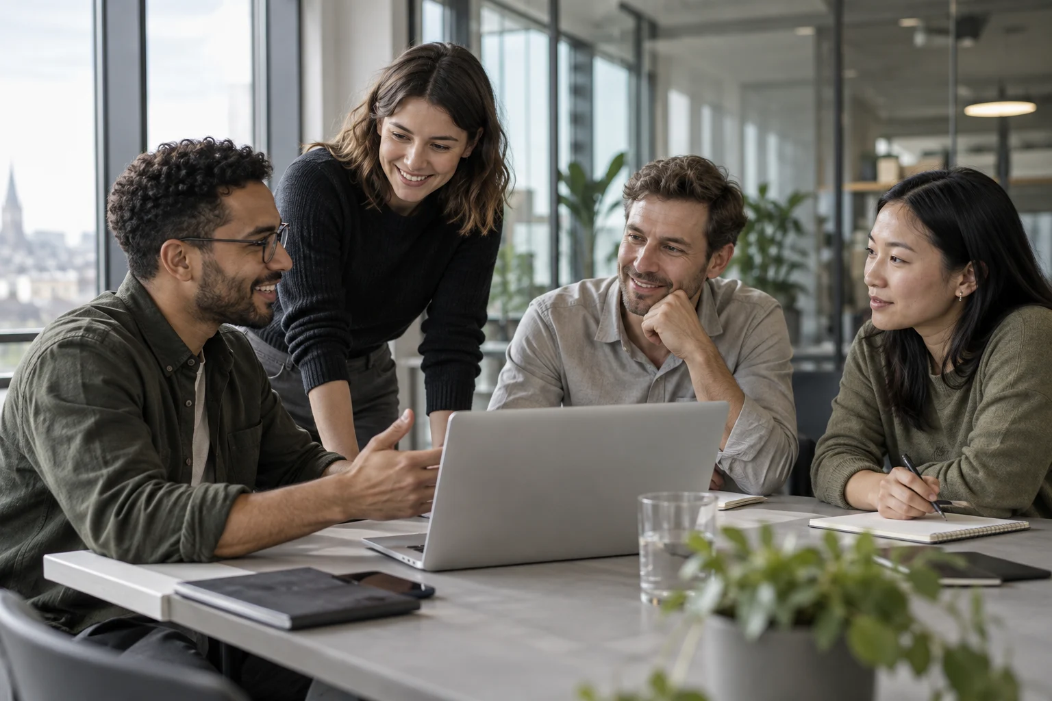 Technology professionals collaborating around a laptop